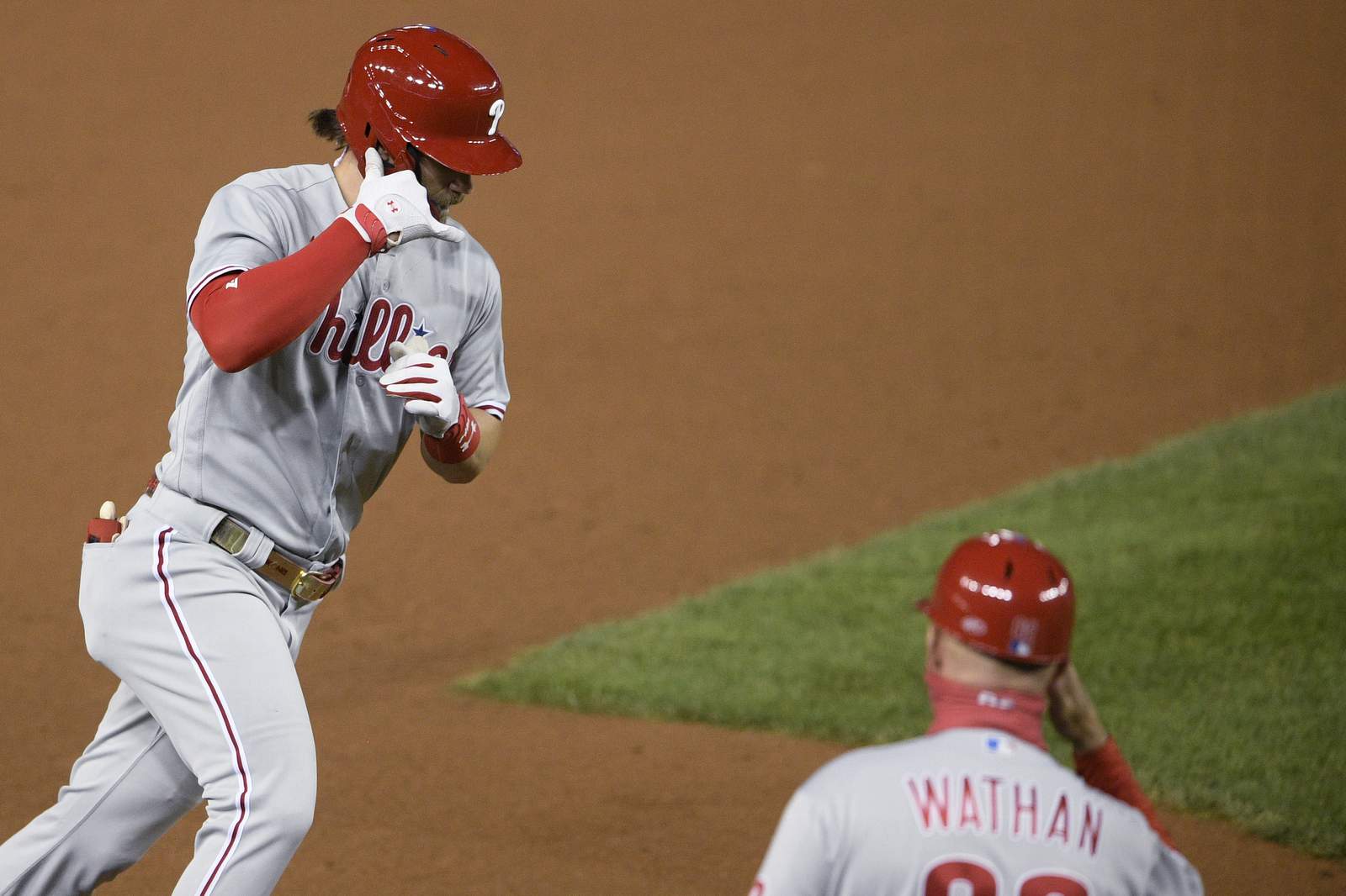 Harper's 2 HRs help Phils top Nats 12-3, eliminate champs