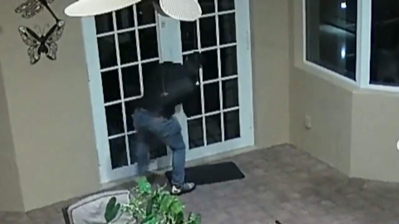 Video shows man repeatedly hurling rock at impact windows in robbery attempt