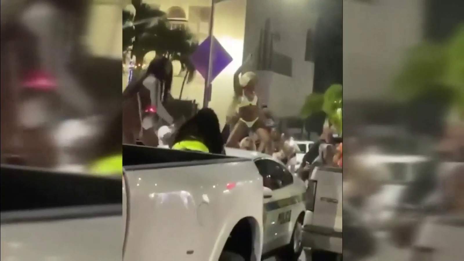 Women jumped onto a police car to twerk on it on Friday night in South Beach. 