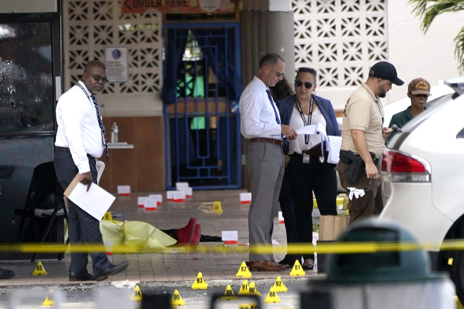 Law enforcement officials work the scene of a shooting outside a banquet hall, Sunday, in Miami-Dade County. (AP Photo/Lynne Sladky)