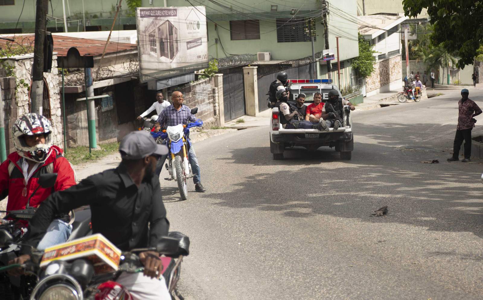 A police truck takes two detainees to the police station of Petion Ville in Port-au-Prince, Haiti, Thursday, July 8, 2021. According to Police Chief Leon Charles, the two detained are suspects in the assassination of Haitian President Jovenel Mose. (AP Photo/Joseph Odelyn)