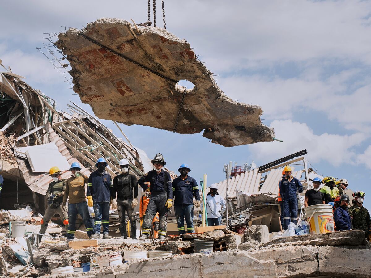 A crane lifts a concrete slab to clear the way for rescuers searching through the rubble three days after an earthquake hit Pereira, Colombia, Thursday, Aug. 13, 2026. (AP Photo/Brandon Pinto)